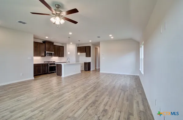 a view of kitchen with microwave a stove and wooden floor