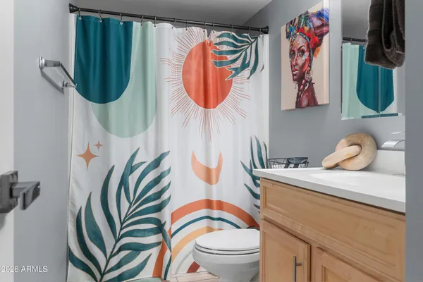 a bathroom with a sink a toilet and shower curtain