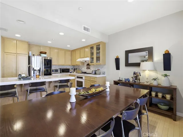 a living room with stainless steel appliances furniture dining table and chairs