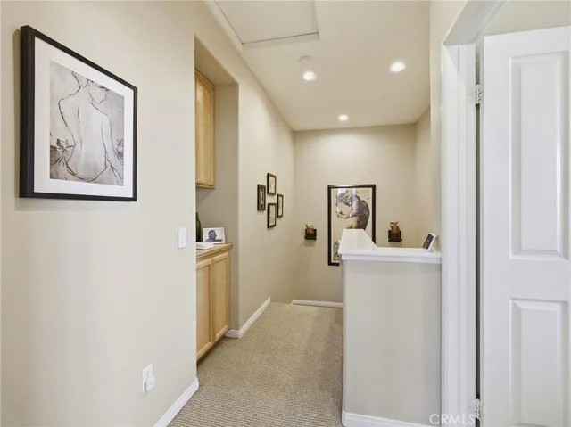 a hallway with painting and a refrigerator