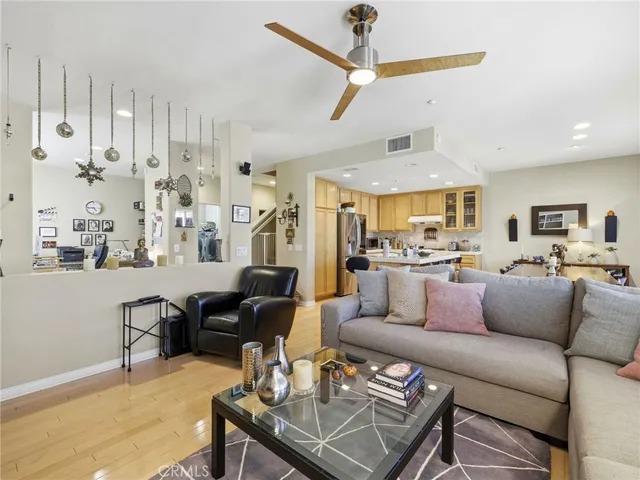 a living room with furniture kitchen view and a chandelier
