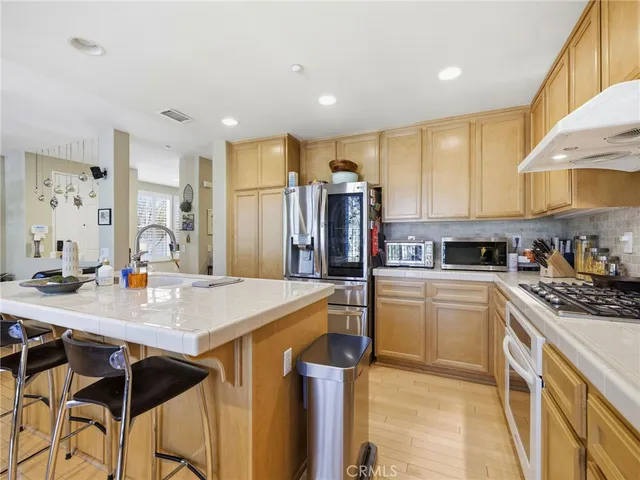 a kitchen with stainless steel appliances granite countertop a stove refrigerator sink and cabinets