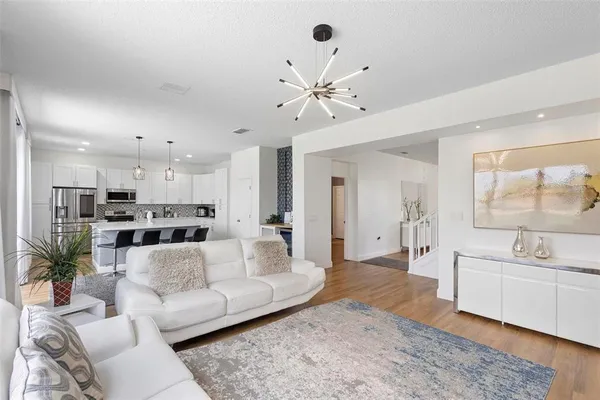 a living room with furniture and view of kitchen