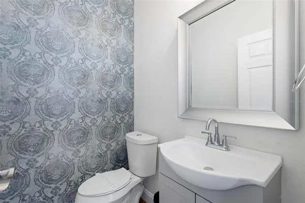 a bathroom with a sink toilet and mirror