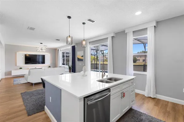 a open kitchen with stainless steel appliances granite countertop a sink and a wooden floor