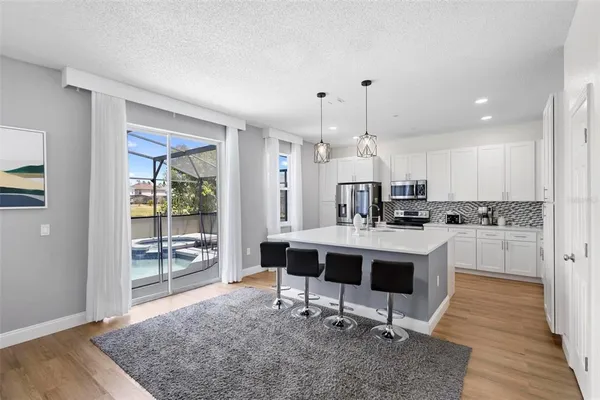 a view of kitchen with sink refrigerator dining table and chairs