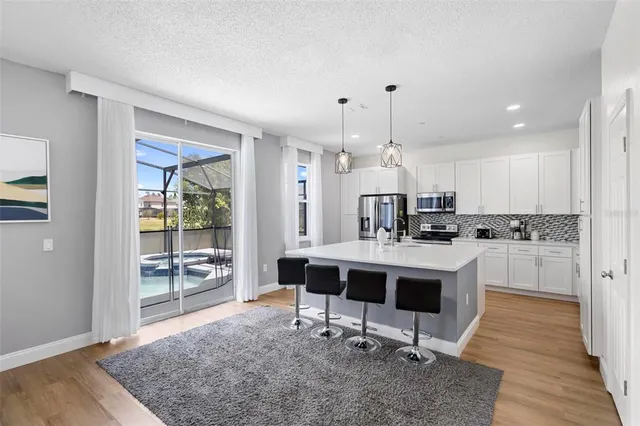 a view of kitchen with sink refrigerator dining table and chairs