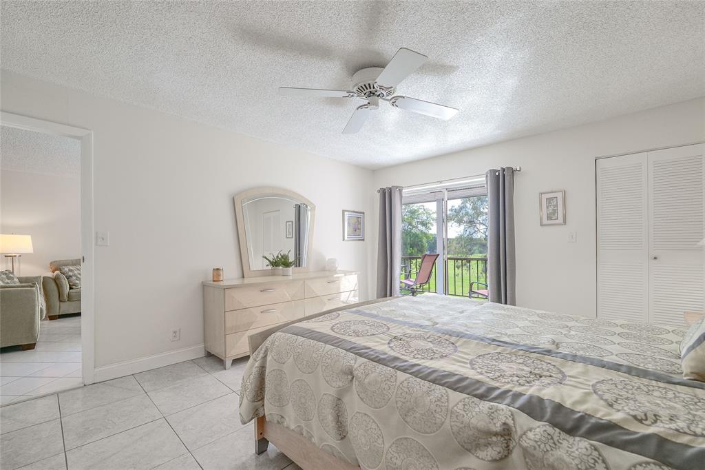 6100 Northwest 44th Street, Unit 307 Lauderhill, FL 33319 - Photo 14 of 54 a bedroom with a large bed and a chandelier