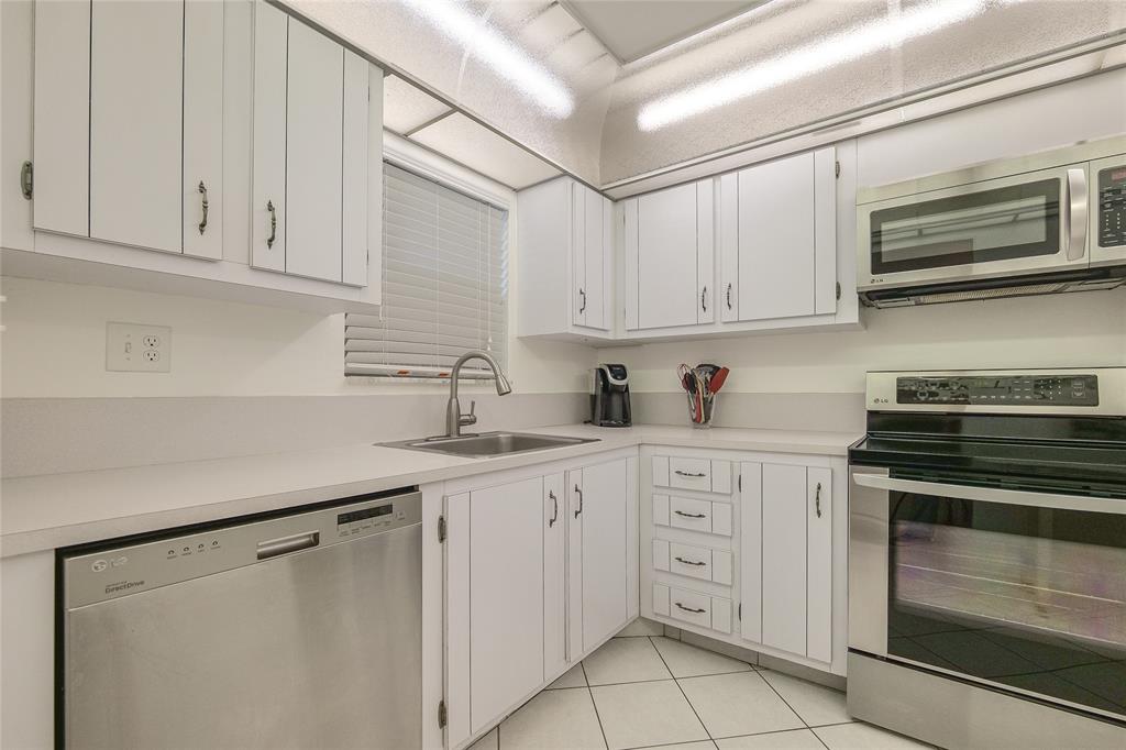 6100 Northwest 44th Street, Unit 307 Lauderhill, FL 33319 - Photo 29 of 54 a kitchen with white cabinets and white appliances