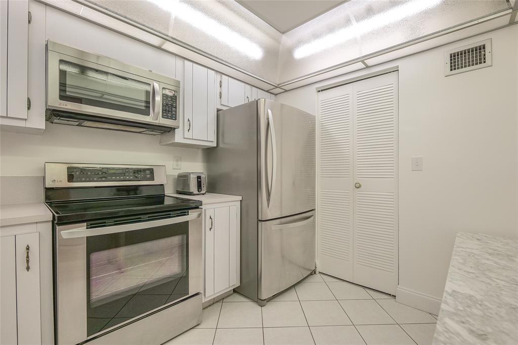 6100 Northwest 44th Street, Unit 307 Lauderhill, FL 33319 - Photo 31 of 54 a kitchen with stainless steel appliances granite countertop a stove a microwave and a refrigerator