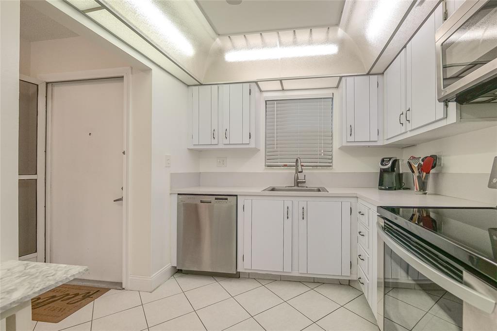 6100 Northwest 44th Street, Unit 307 Lauderhill, FL 33319 - Photo 36 of 54 a kitchen with white cabinets a sink and appliances