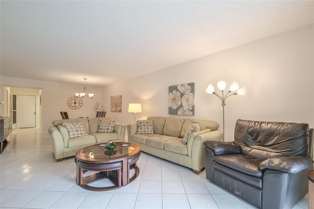 6100 Northwest 44th Street, Unit 307 Lauderhill, FL 33319 - Photo 4 of 54 a living room with furniture and a chandelier