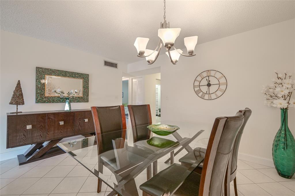 6100 Northwest 44th Street, Unit 307 Lauderhill, FL 33319 - Photo 7 of 54 a view of a dining room with furniture and a chandelier