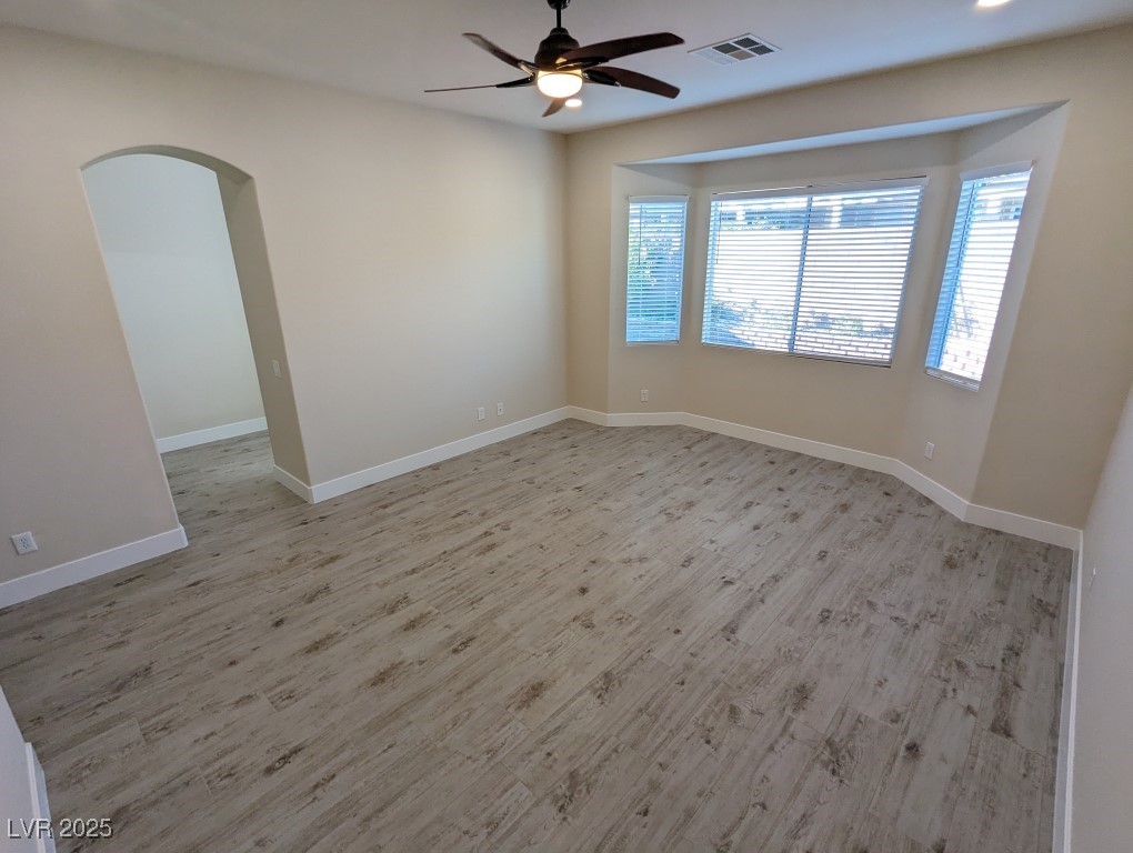 9976 Liberty View Road Las Vegas, NV 89148 - Photo 15 of 44 Spare room featuring arched walkways, light wood-style flooring, and ceiling fan