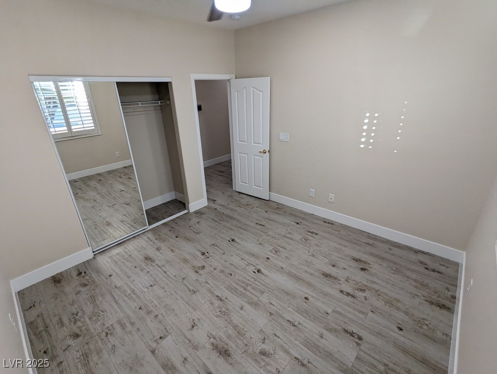 9976 Liberty View Road Las Vegas, NV 89148 - Photo 25 of 44 Unfurnished bedroom with light wood-style flooring, a ceiling fan, and a closet