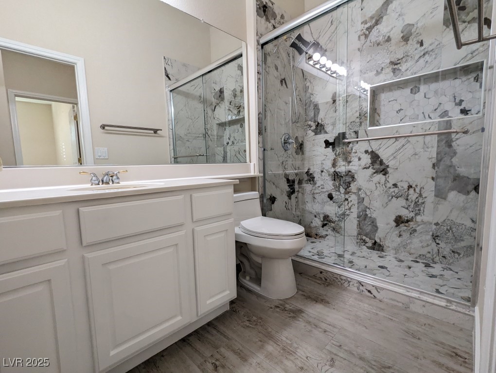 9976 Liberty View Road Las Vegas, NV 89148 - Photo 26 of 44 Full bath with vanity, a marble finish shower, and light wood-style floors