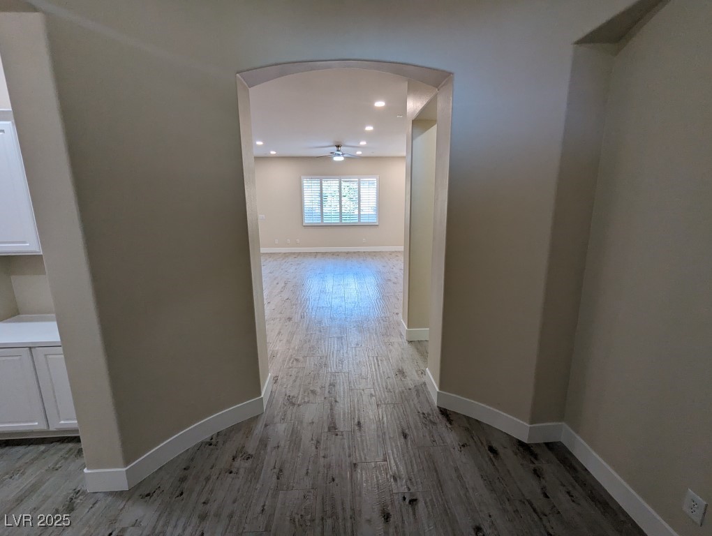 9976 Liberty View Road Las Vegas, NV 89148 - Photo 3 of 44 Hallway featuring arched walkways, light wood finished floors, and recessed lighting