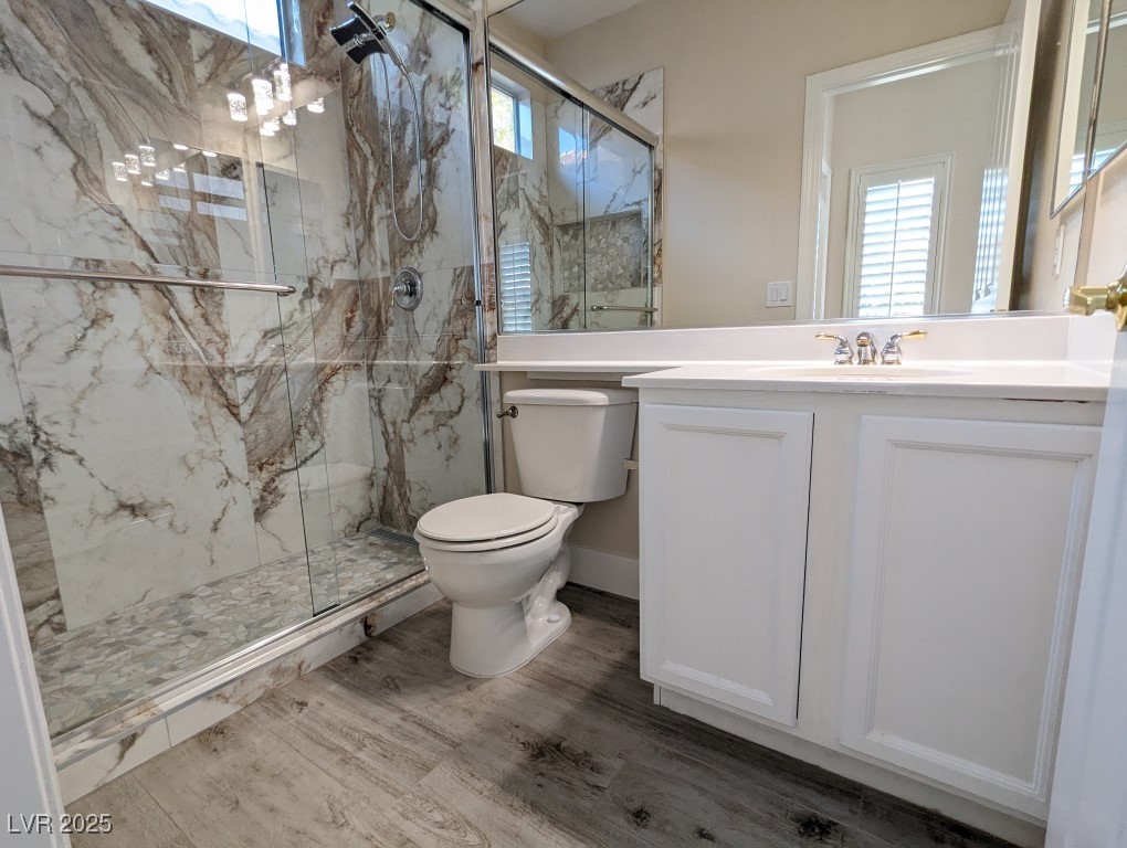 9976 Liberty View Road Las Vegas, NV 89148 - Photo 36 of 44 Bathroom featuring a marble finish shower, vanity, and wood finished floors