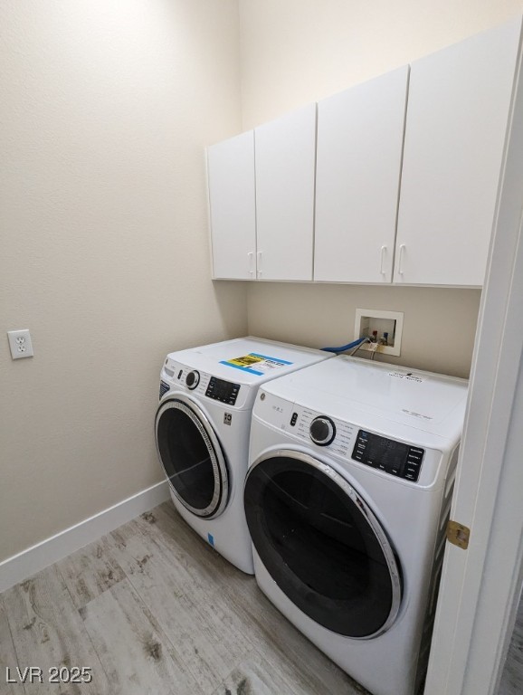 9976 Liberty View Road Las Vegas, NV 89148 - Photo 39 of 44 Laundry room with cabinet space, light wood-style floors, and washing machine and clothes dryer