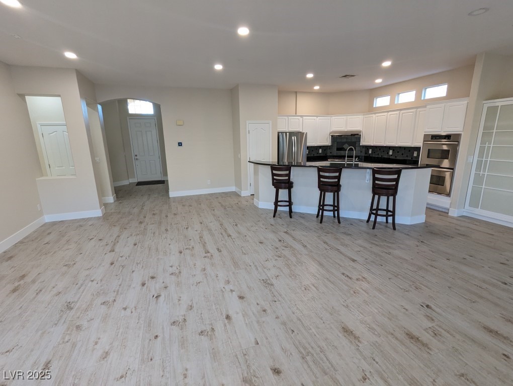 9976 Liberty View Road Las Vegas, NV 89148 - Photo 42 of 44 Kitchen with open floor plan, white cabinetry, stainless steel appliances, recessed lighting, and a kitchen breakfast bar