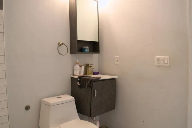 a bathroom with a toilet sink and mirror