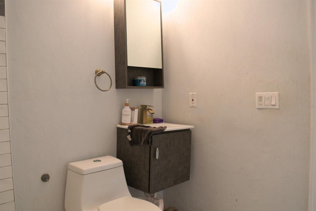 10607 Fernando Street Orlando, FL 32825 - Photo 12 of 19 a bathroom with a toilet sink and mirror