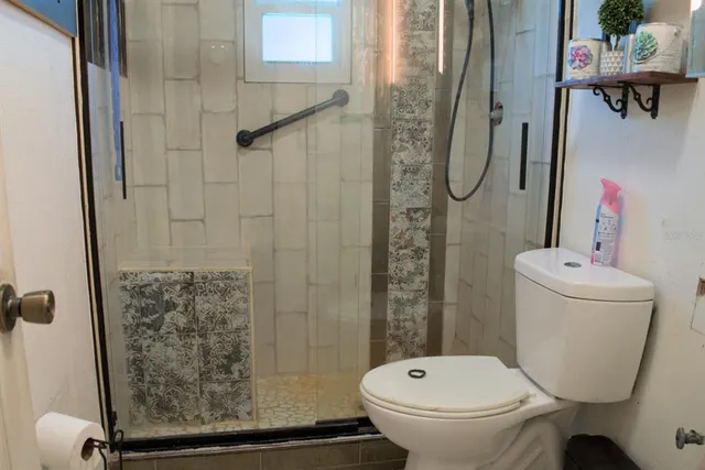 a bathroom with a toilet and a shower