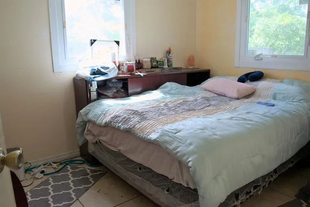 a bedroom with a bed and a window