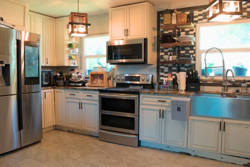 10607 Fernando Street Orlando, FL 32825 - Photo 9 of 19 a kitchen with stainless steel appliances a stove microwave and refrigerator