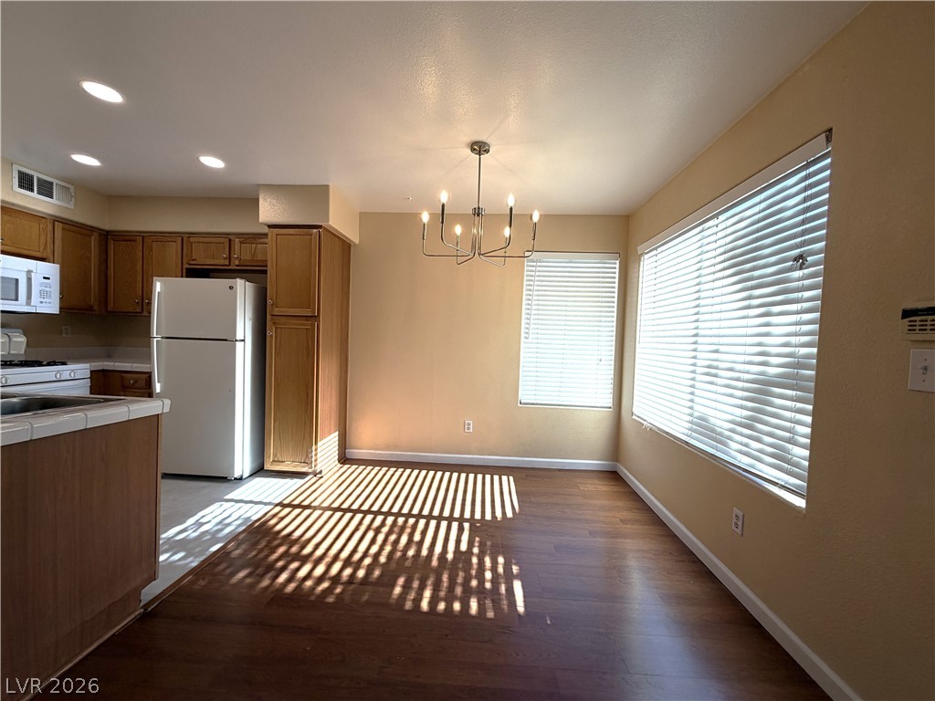 4955 South Lindell Road, Unit 203 Las Vegas, NV 89118 - Photo 4 of 31 Natural light bathes this comfortable dining area featuring rich hardwood floors and a modern light fixture.