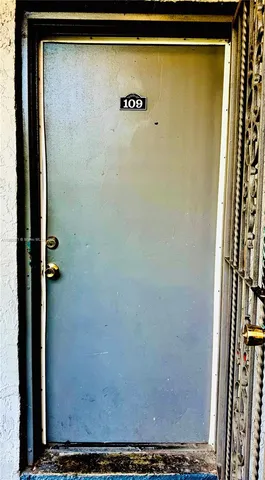 a view of a livingroom with wooden floor and bathroom