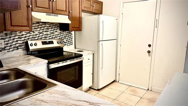a kitchen with a stove a sink and a refrigerator
