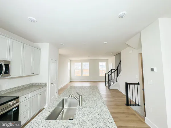 a kitchen with stainless steel appliances granite countertop a stove a sink and a granite counter tops with white cabinets