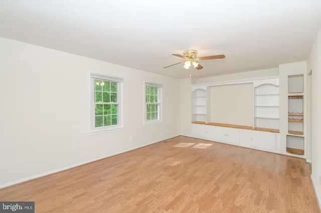 an empty room with closet and windows