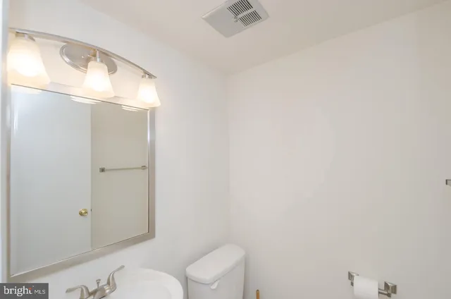 a bathroom with a toilet and a mirror
