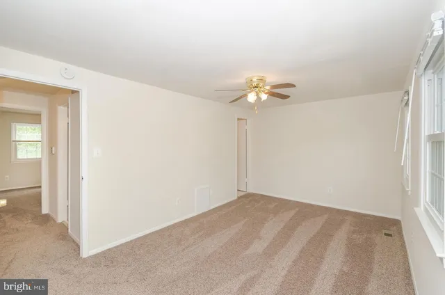 an empty room with a chandelier fan