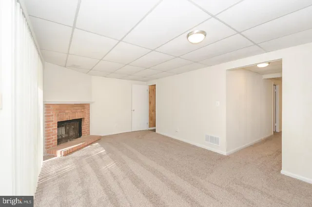 a view of empty room with fan and fireplace