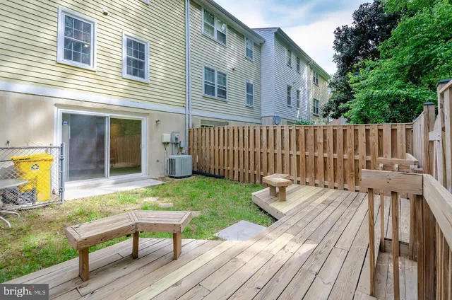 a backyard of a house with wooden floor chairs and wooden fence