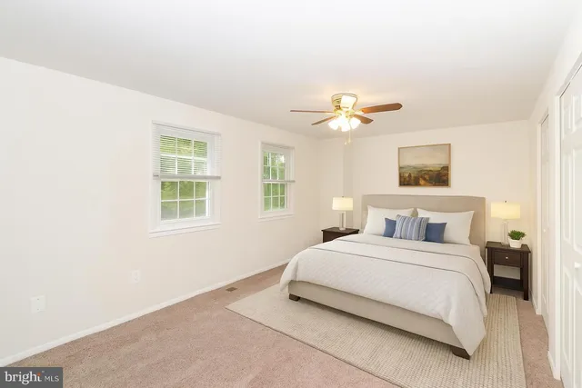 a bedroom with a bed and a ceiling fan