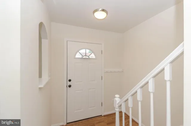 a view of a hallway with wooden floor and staircase