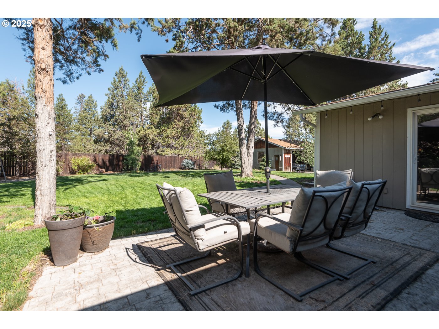 60811 Windsor Drive Bend, OR 97702 - Photo 5 of 27 a patio with a patio table and chairs
