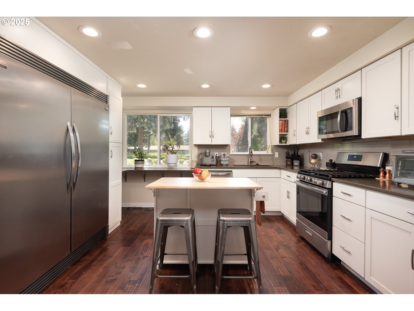 60811 Windsor Drive Bend, OR 97702 - Photo 6 of 27 a kitchen with stainless steel appliances granite countertop a refrigerator a sink dishwasher a stove and white cabinets with wooden floor