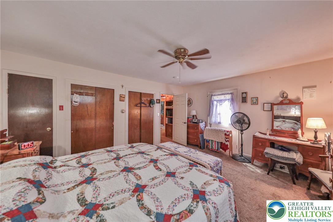 331 Cranberry Creek Road Cresco, PA 18326 - Photo 47 of 95 The carpeted bedroom features a functional ceiling fan and ample closet space, ensuring comfort and utility.