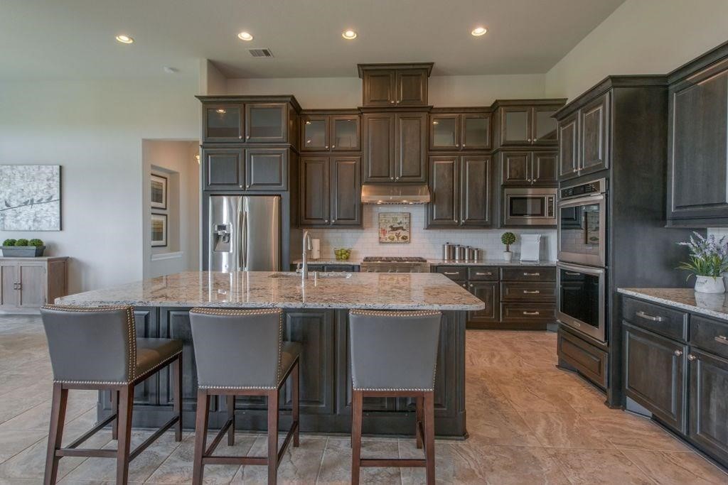 26519 Ashley Ridge Lane Katy, TX 77494 - Photo 10 of 28 a kitchen with stainless steel appliances granite countertop a table chairs sink and cabinets