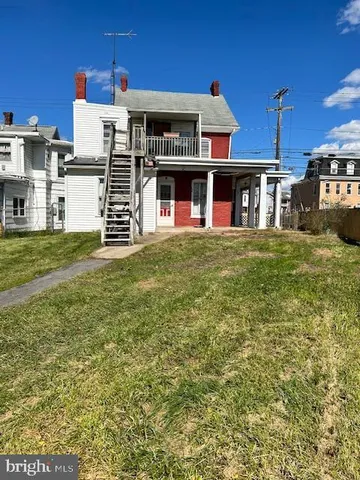 a view of a big house with a big yard and large trees
