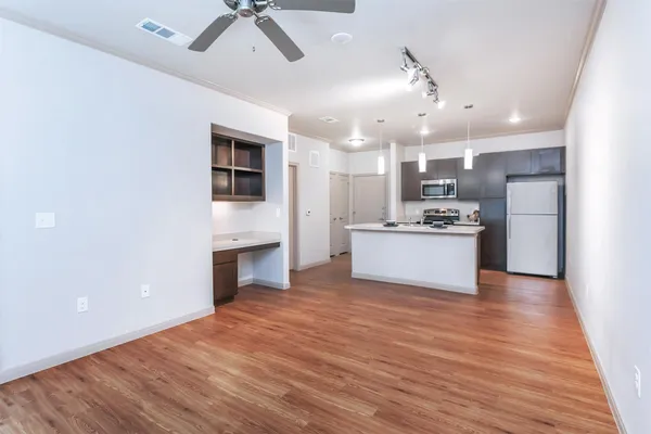 a kitchen with a refrigerator a stove a microwave and cabinets with wooden floor