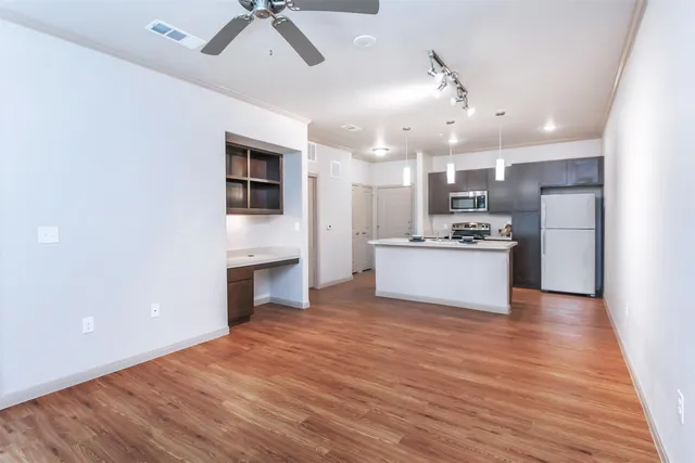 a kitchen with a refrigerator a stove a microwave and cabinets with wooden floor