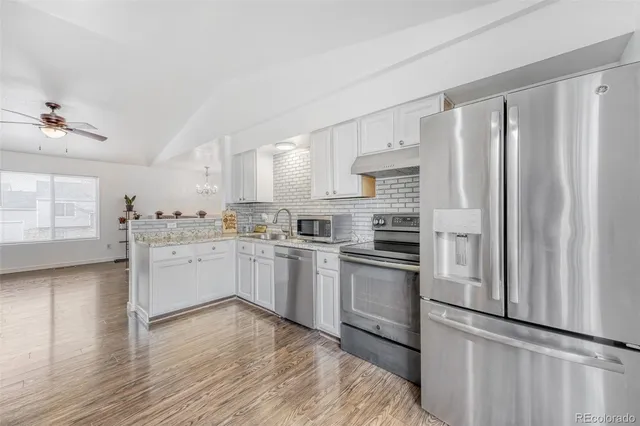 a kitchen with granite countertop stainless steel appliances and white cabinets