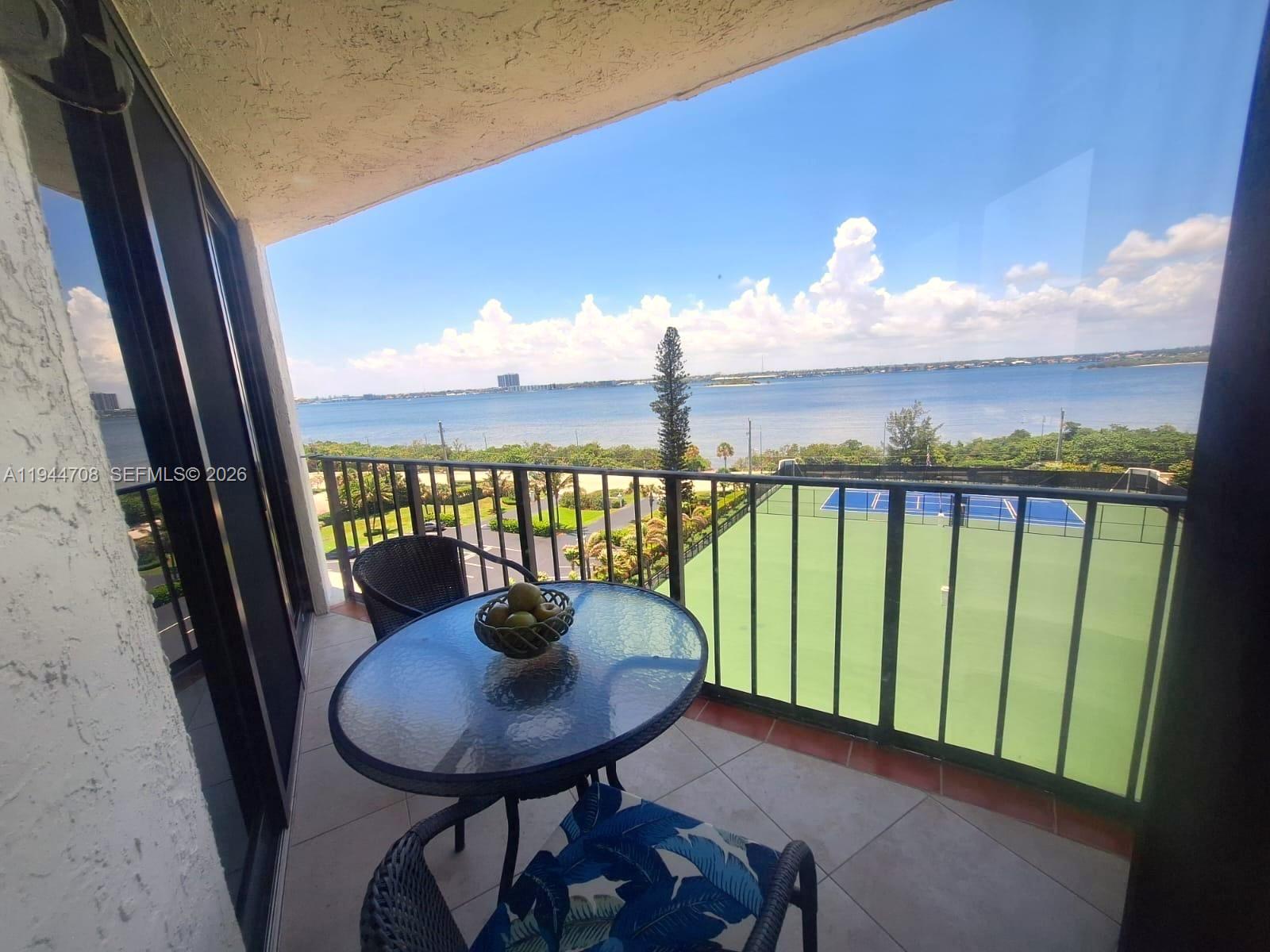 5420 North Ocean Drive, Unit 706 Singer Island, FL 33404 - Photo 15 of 41 a view of a balcony with a table and chairs and wooden floor