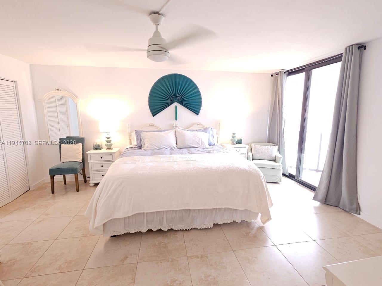 5420 North Ocean Drive, Unit 706 Singer Island, FL 33404 - Photo 17 of 41 a spacious bedroom with a bed and a chandelier